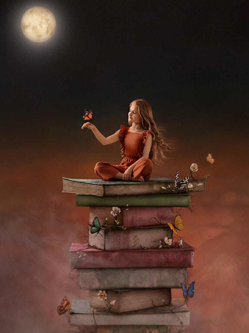 Award winning image of a child sitting on a pile of giant books with butterflies