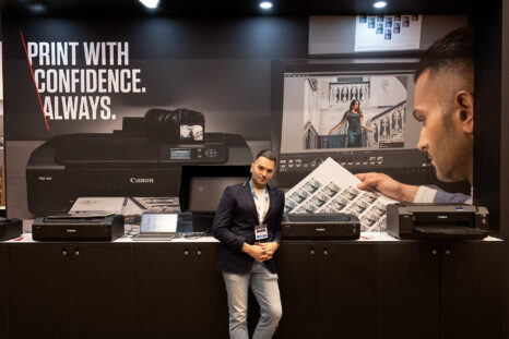 image of an indian man standing in front of a bank of printers, reviewing images, while promoting sanjay jogia workshop at Click Live this summer. 